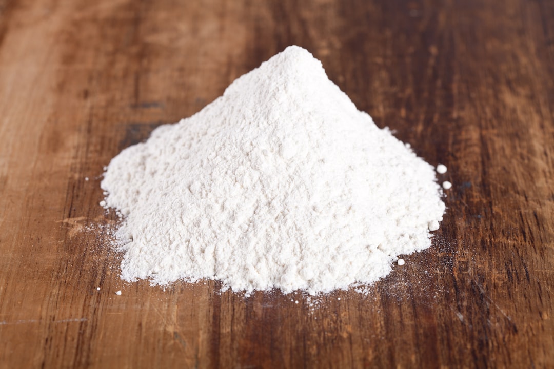 Weißes Calciumcarbonat-Pulver auf einer Holzoberfläche – typische Form des Kalkdüngers